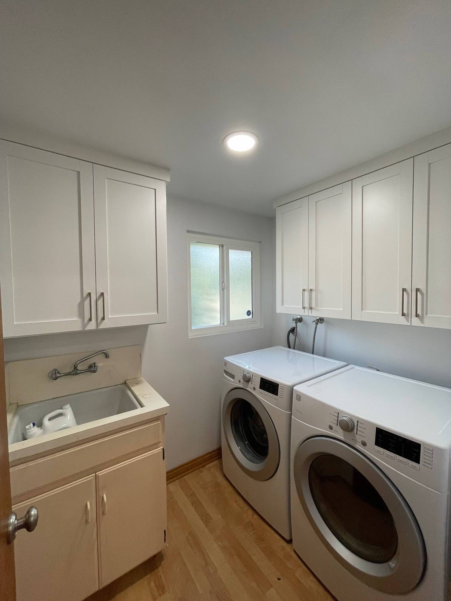 a custom laundry room cabinets with two washing machines and a sink