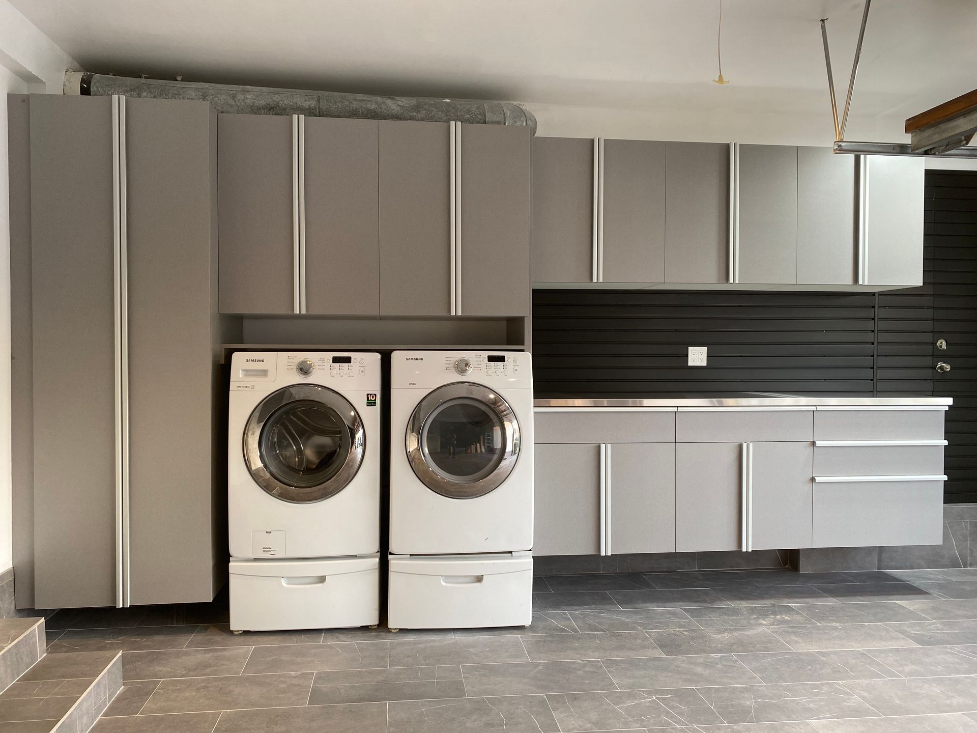 garage cabinetry surrounding a washer and dryer