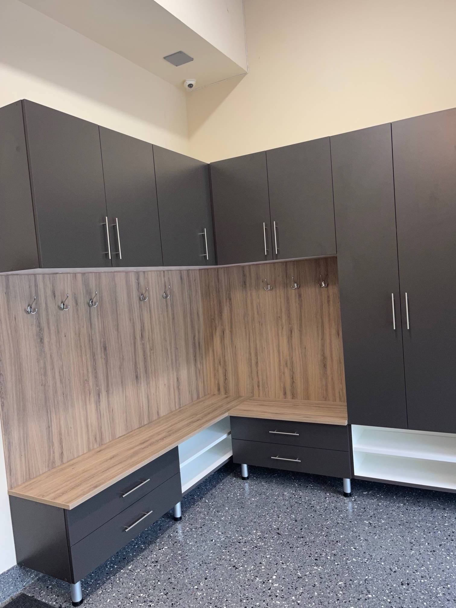a mudroom with a lot of cabinets and drawers and a bench .