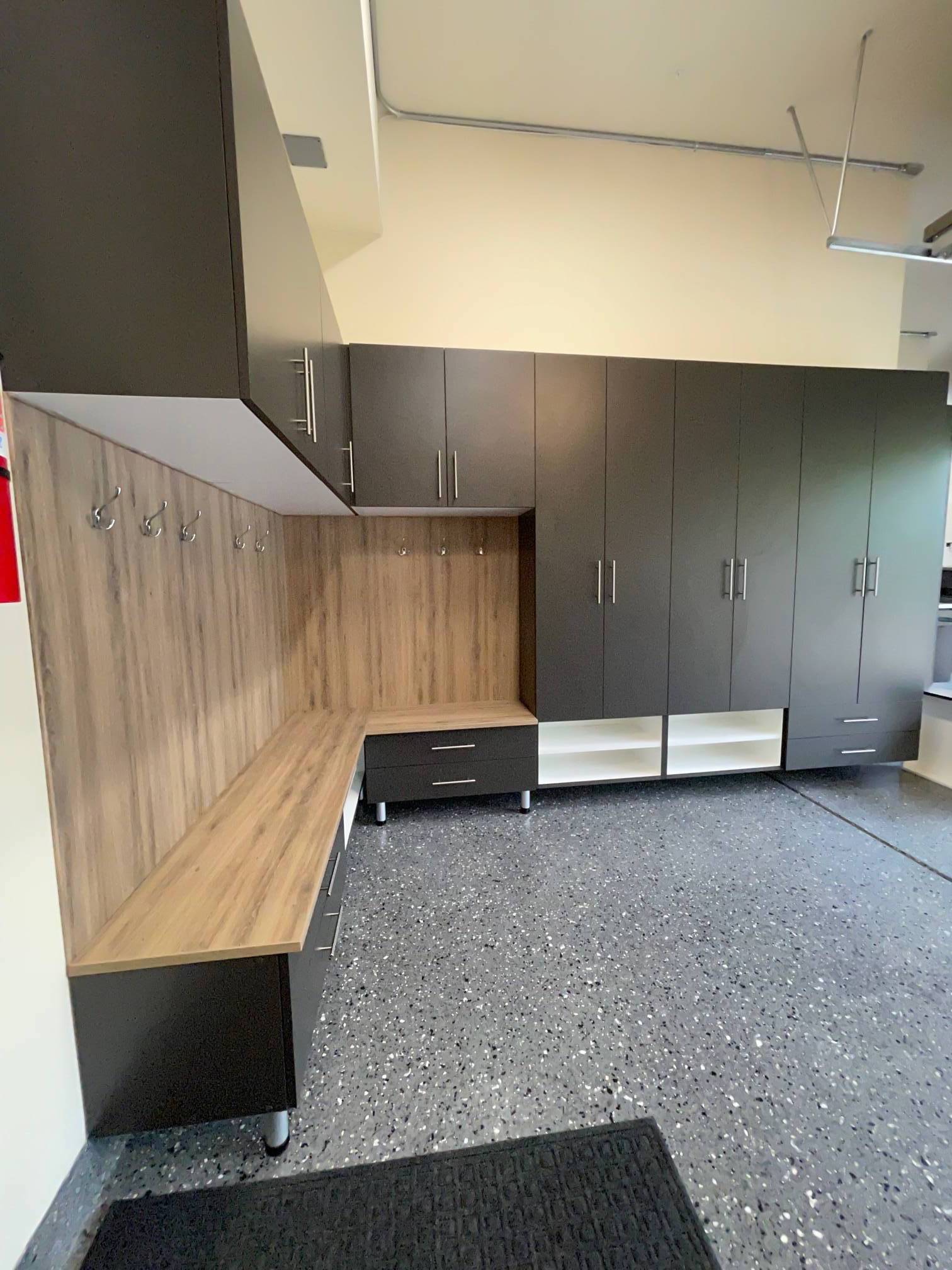 a mudroom with lots of cabinets and a bench .