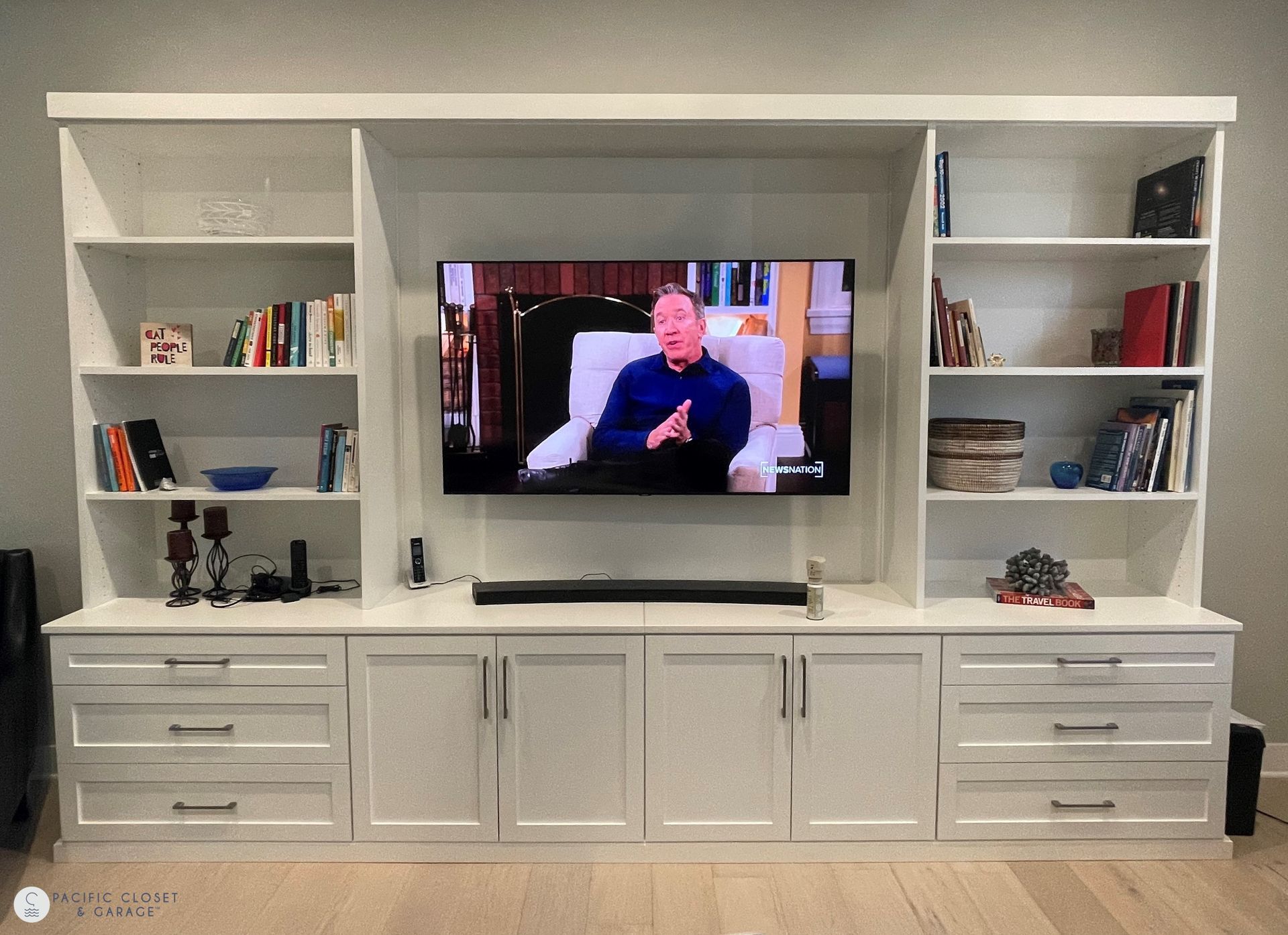 a large entertainment center with a flat screen tv mounted to the wall .