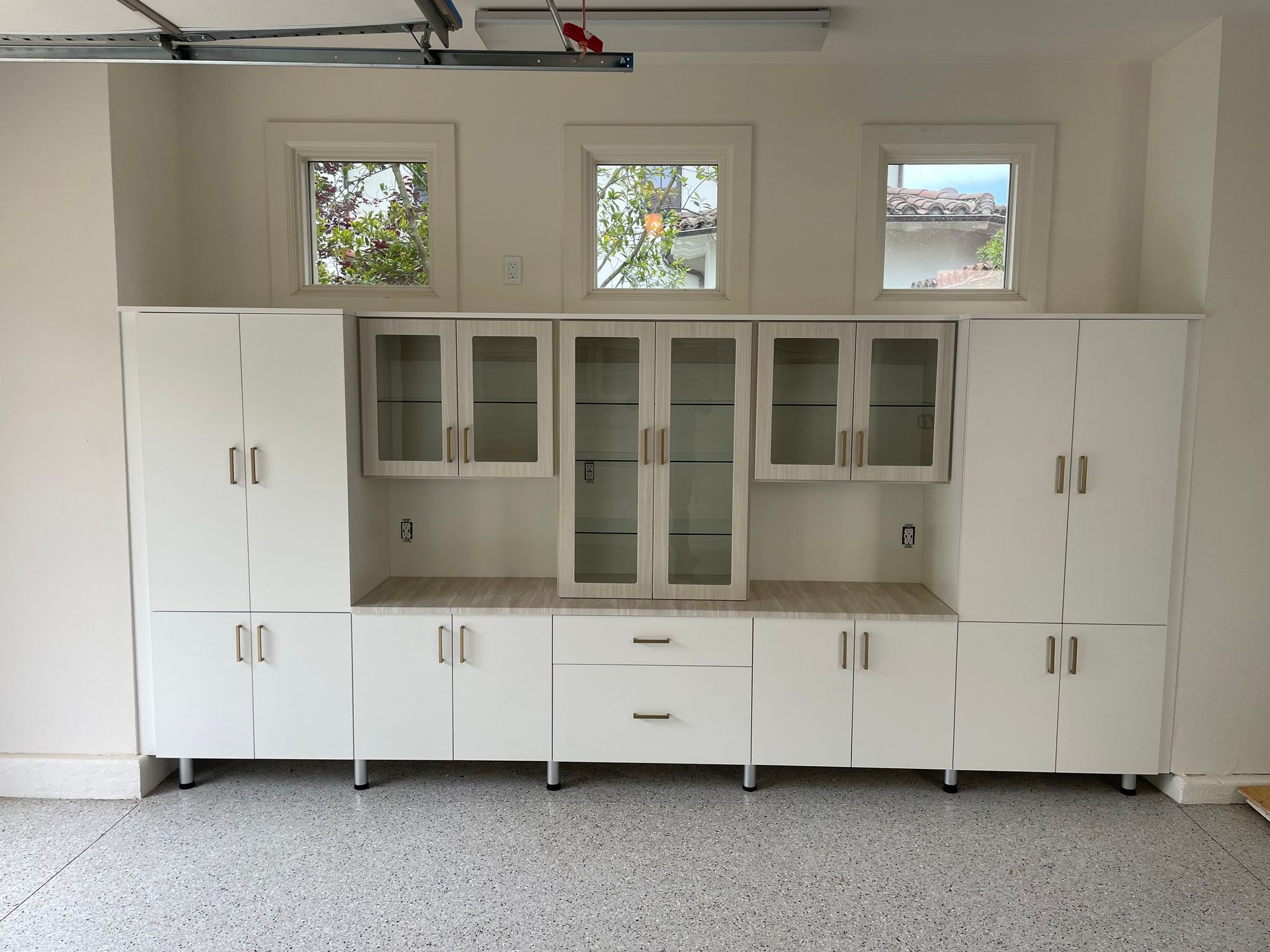 a garage with a lot of white cabinets and drawers