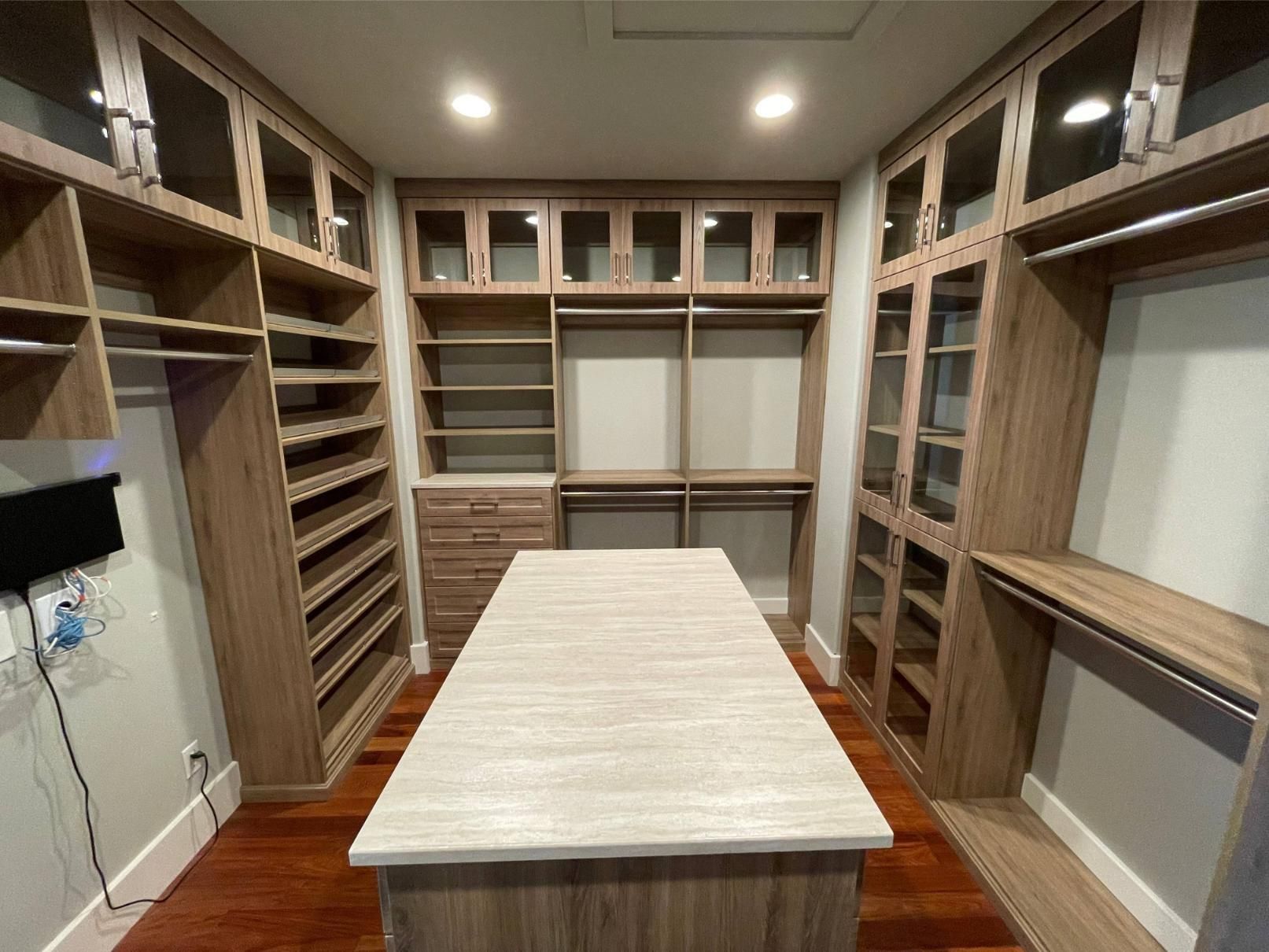 A walk in closet with a large island in the middle.