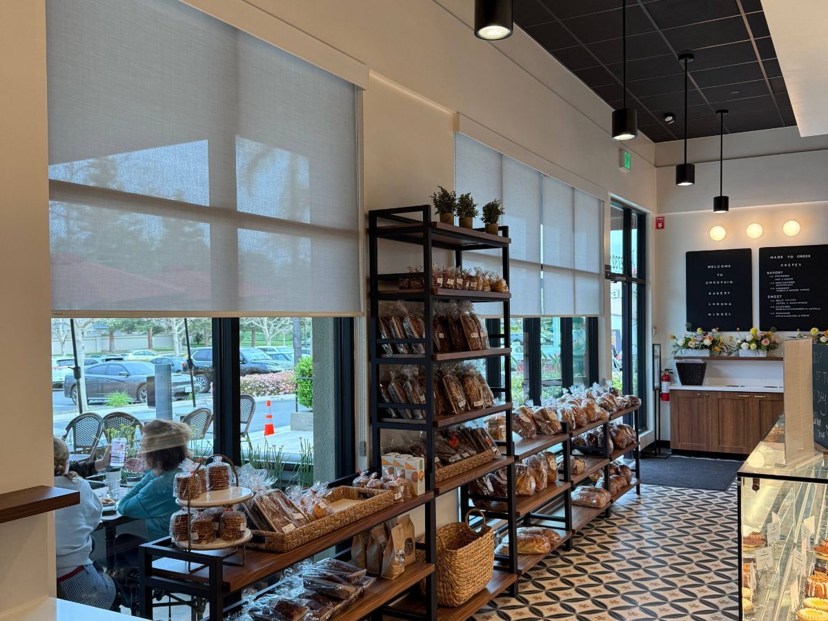 A woman is sitting at a table in a bakery.