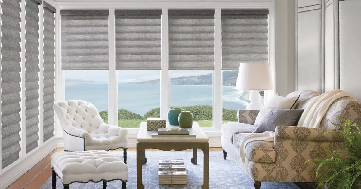 A living room with a couch , chair , table and sliding glass doors.