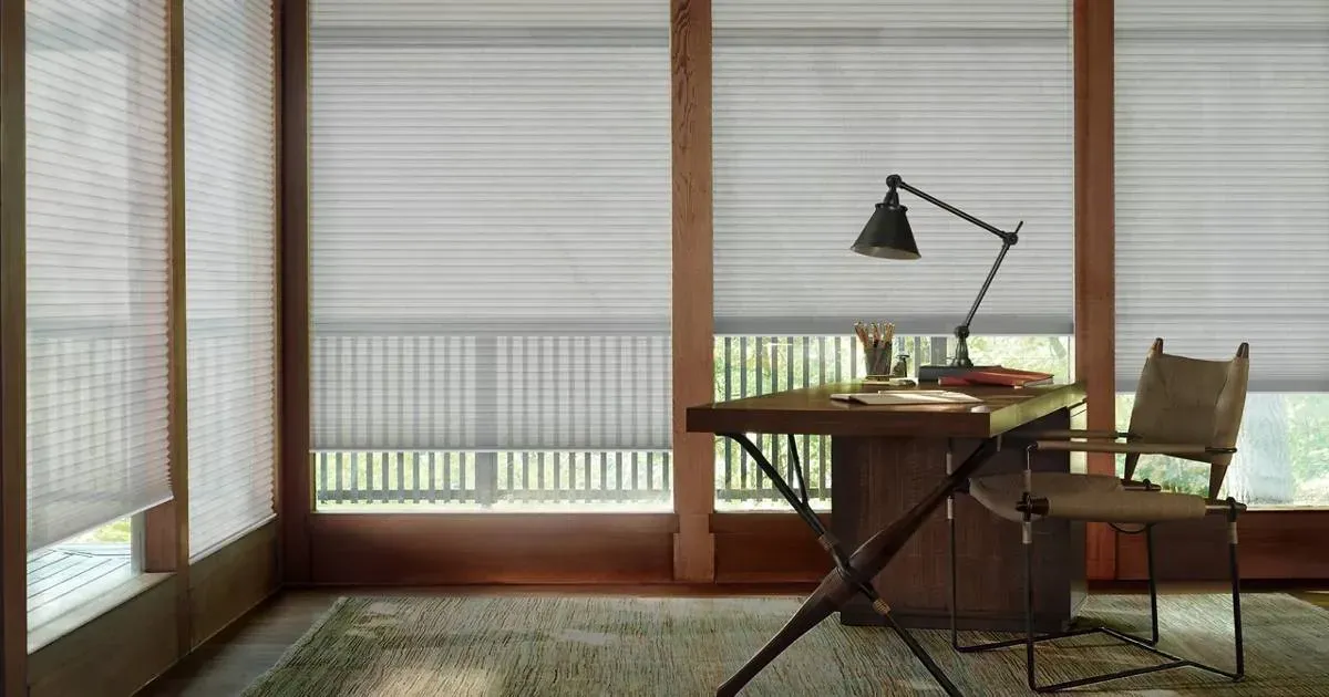 There is a desk and chair in the room with a lamp.