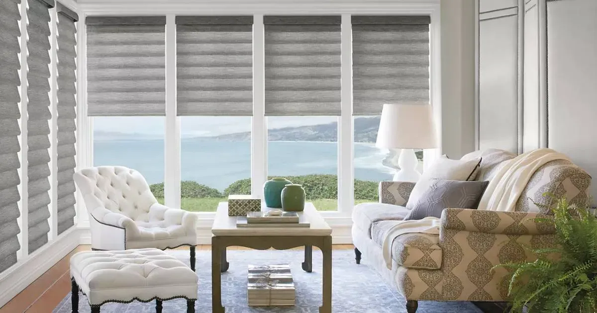A living room with a couch , chair , coffee table and sliding glass doors.
