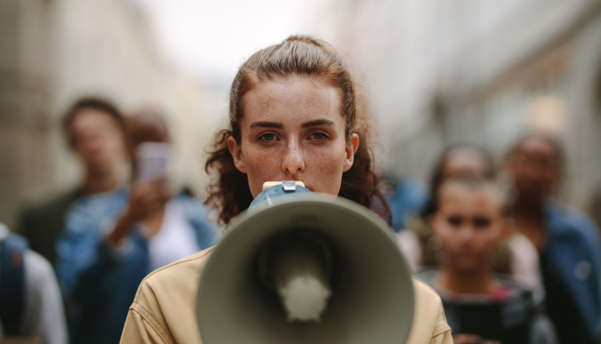 Woman with megaphone leads a protest march.