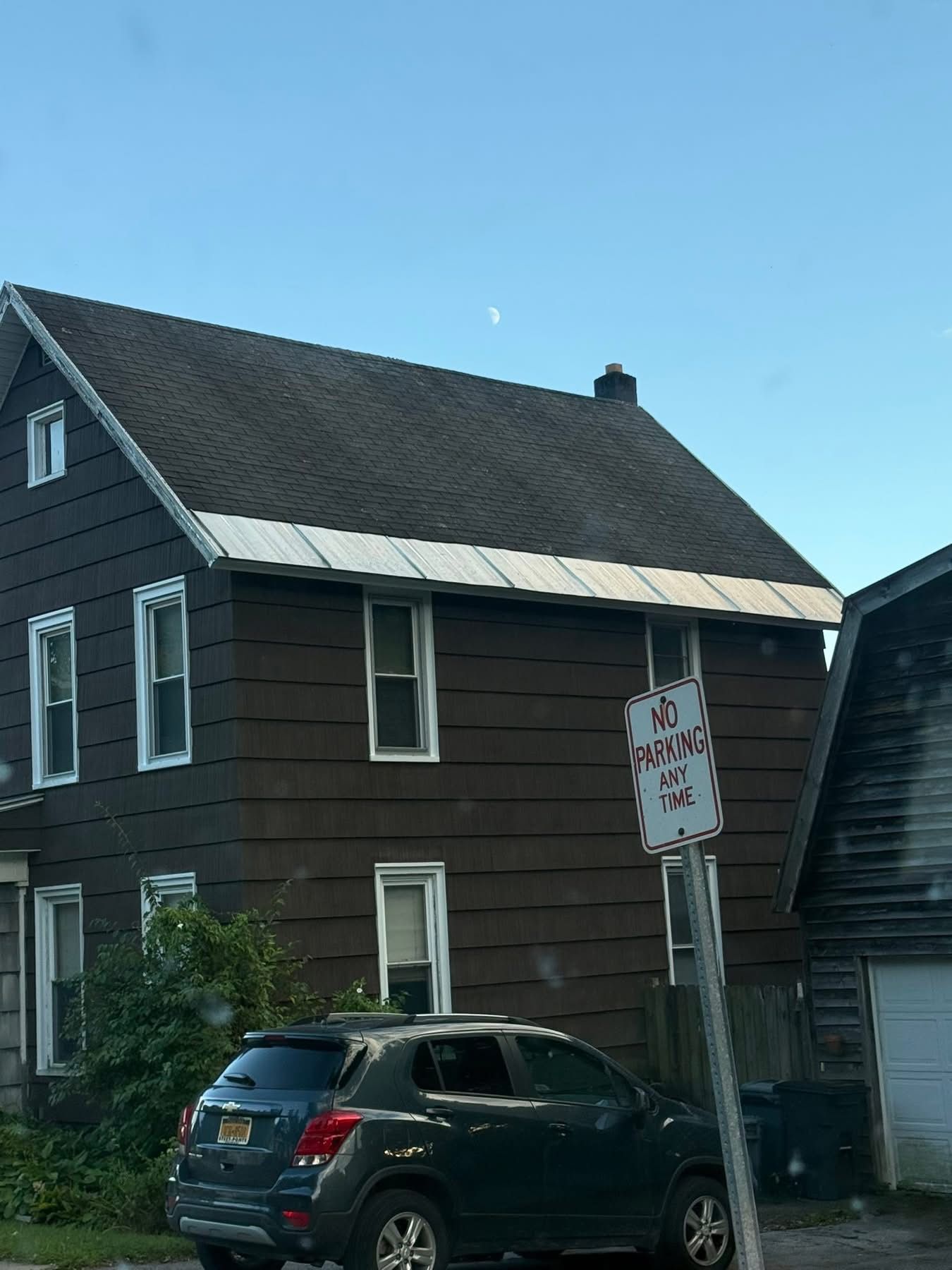 Brown two-story house with a car parked in front, with a 