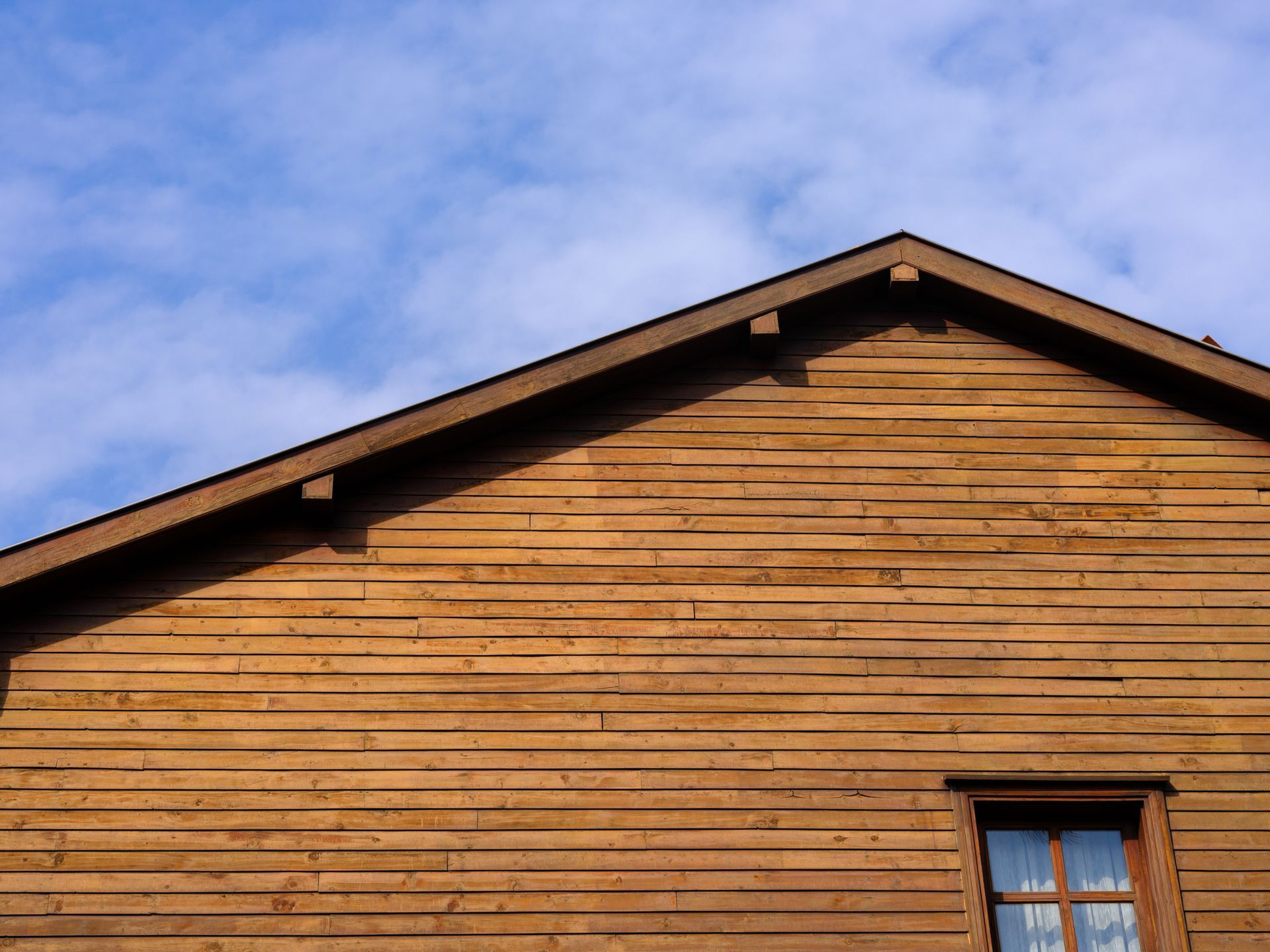 A wooden house with a blue sky in the background