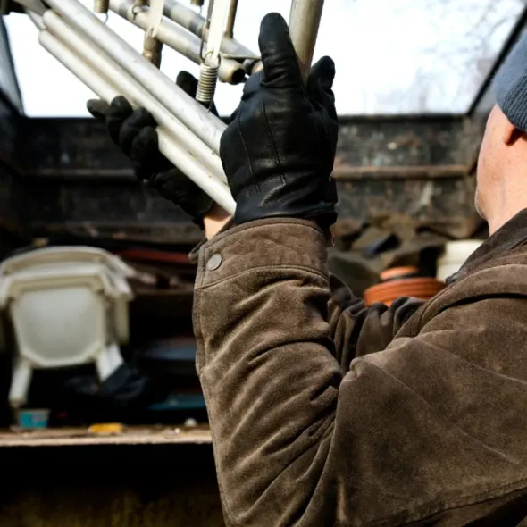 A man in a brown jacket is holding a trumpet