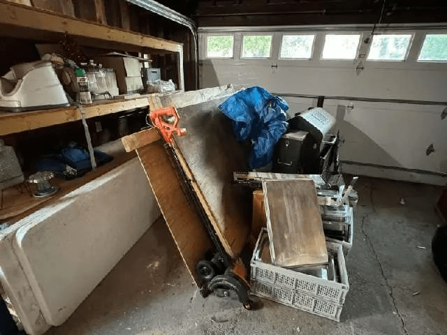 A garage filled with lots of junk and a table.