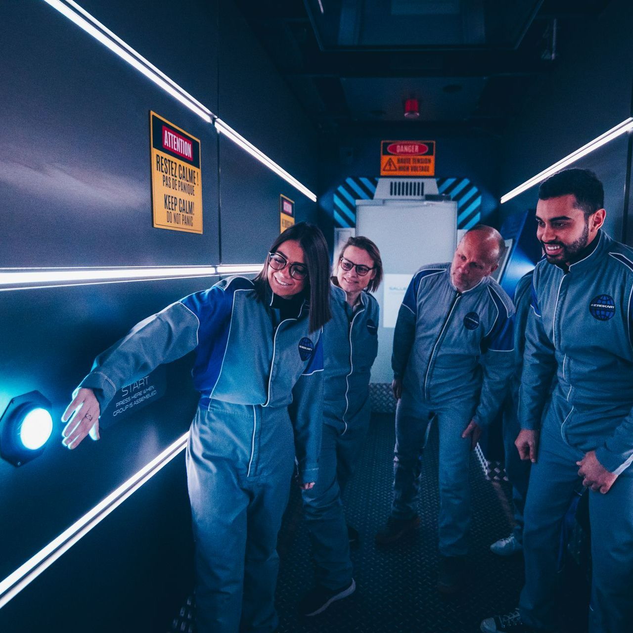 Un groupe de personnes debout dans un couloir avec un panneau sur le mur indiquant « avertissement »