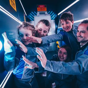 Un groupe de personnes pose pour une photo dans une pièce sombre
