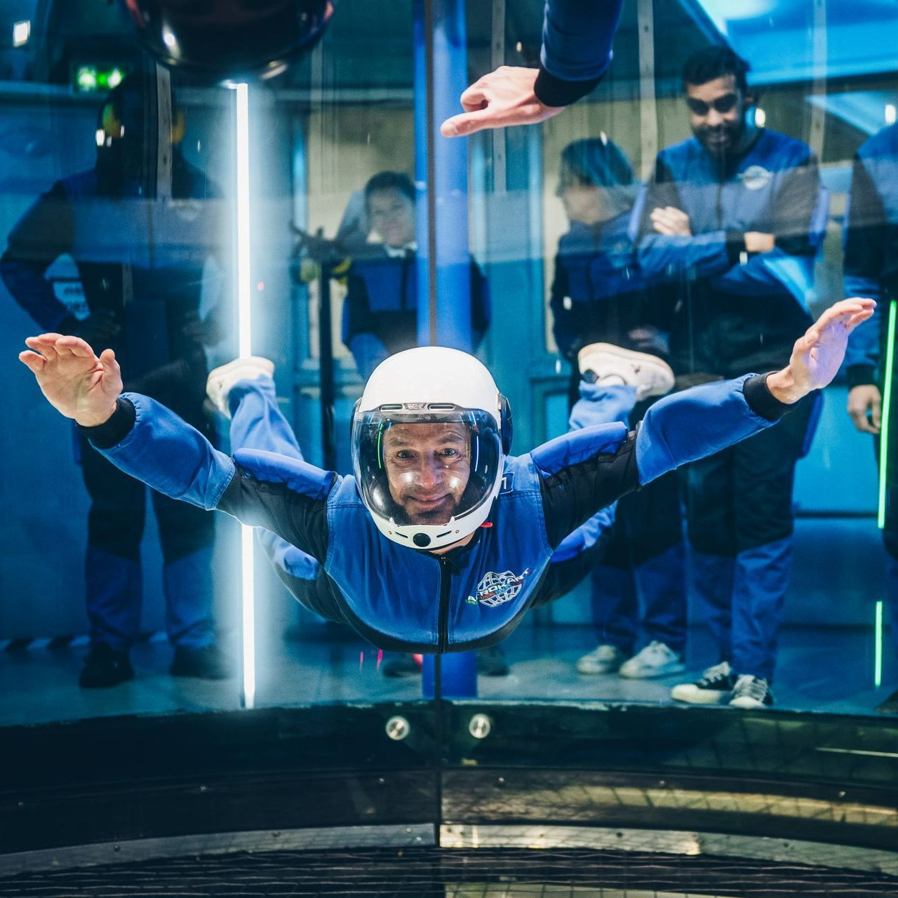Un homme portant un casque vole à travers un mur de verre.