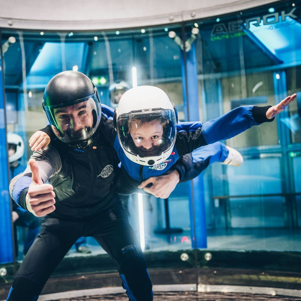 Deux personnes portant des casques lèvent le pouce