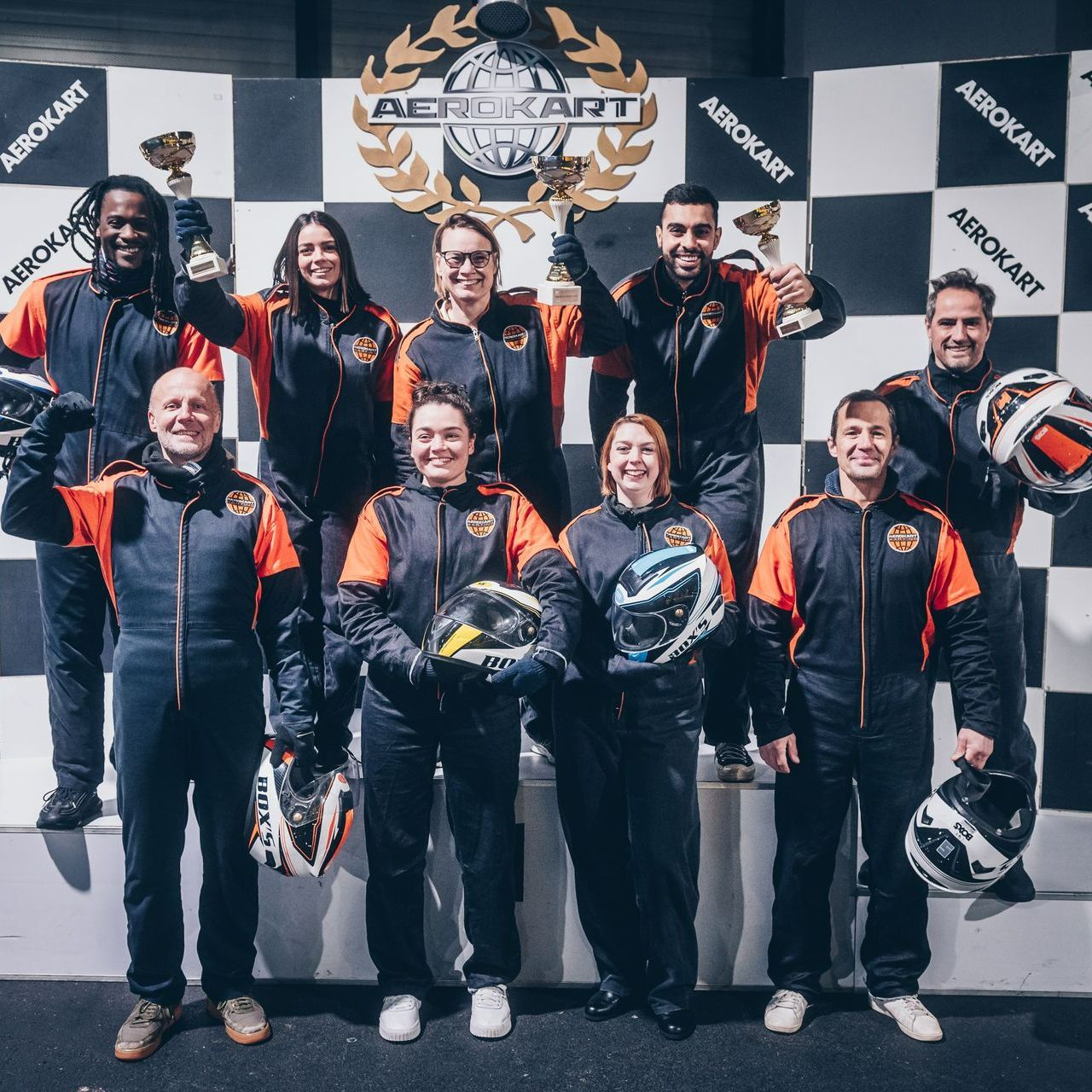 Un groupe de personnes debout devant un mur sur lequel est écrit aerokart