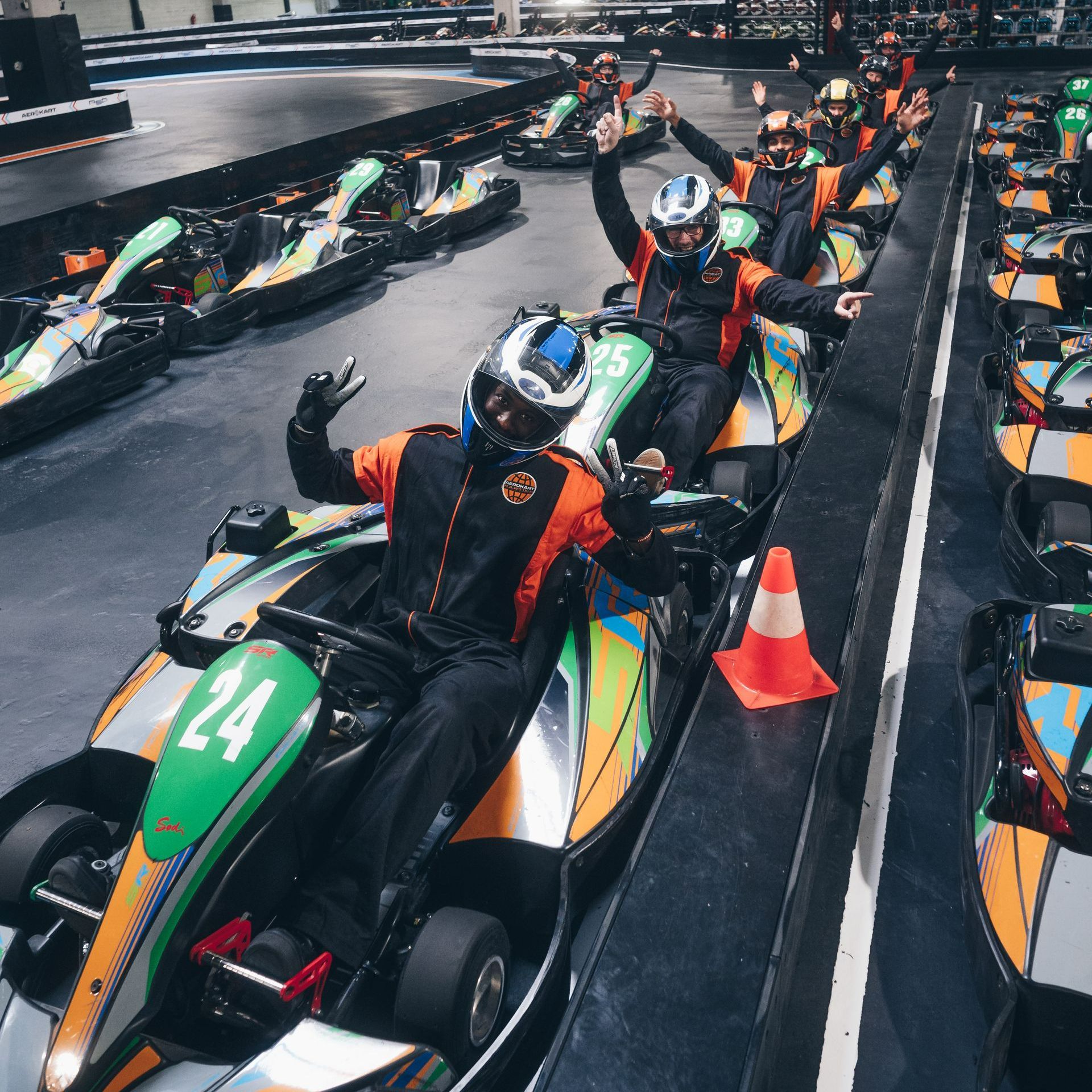 Un groupe de personnes conduisent des karts avec le numéro 24 sur le devant.