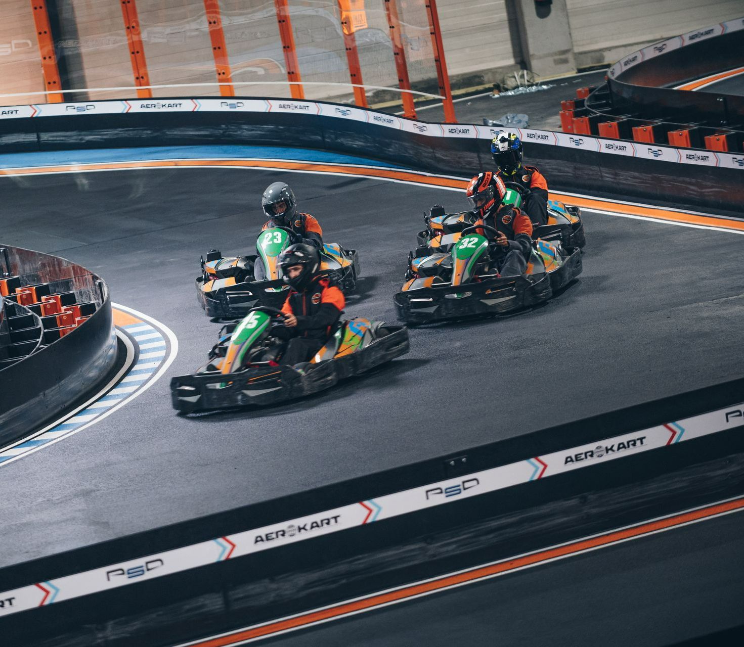 Un groupe de personnes font du kart sur une piste.
