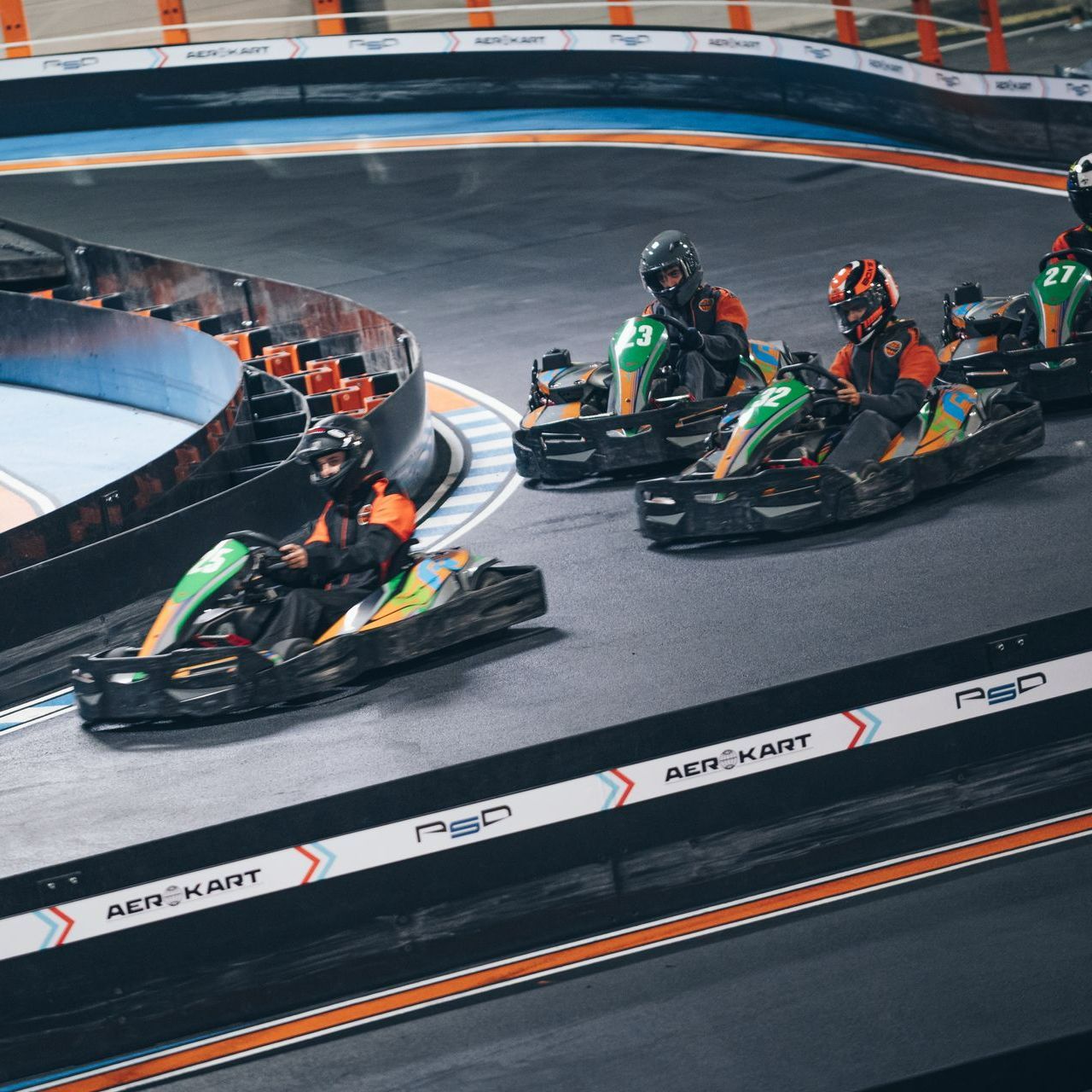 Un groupe de personnes font du kart sur une piste.