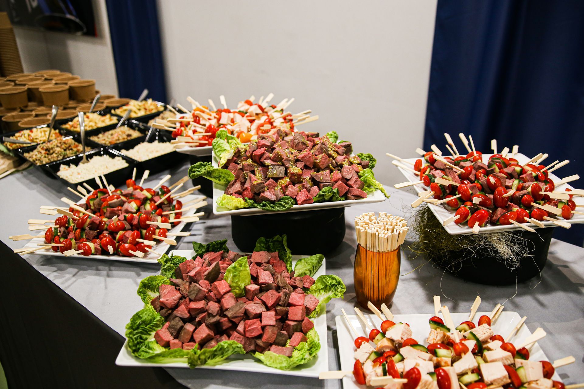 Une table surmontée d'assiettes de nourriture et de brochettes de nourriture.