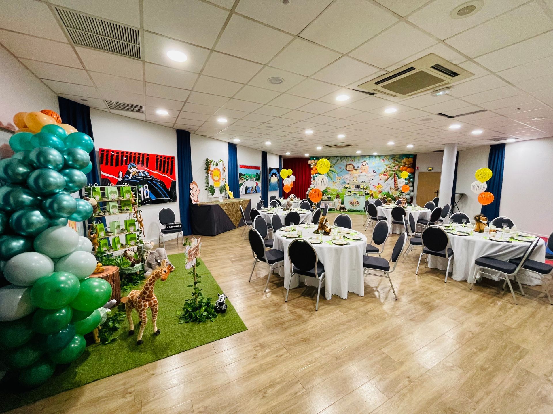 Une grande salle remplie de tables, de chaises et de ballons.