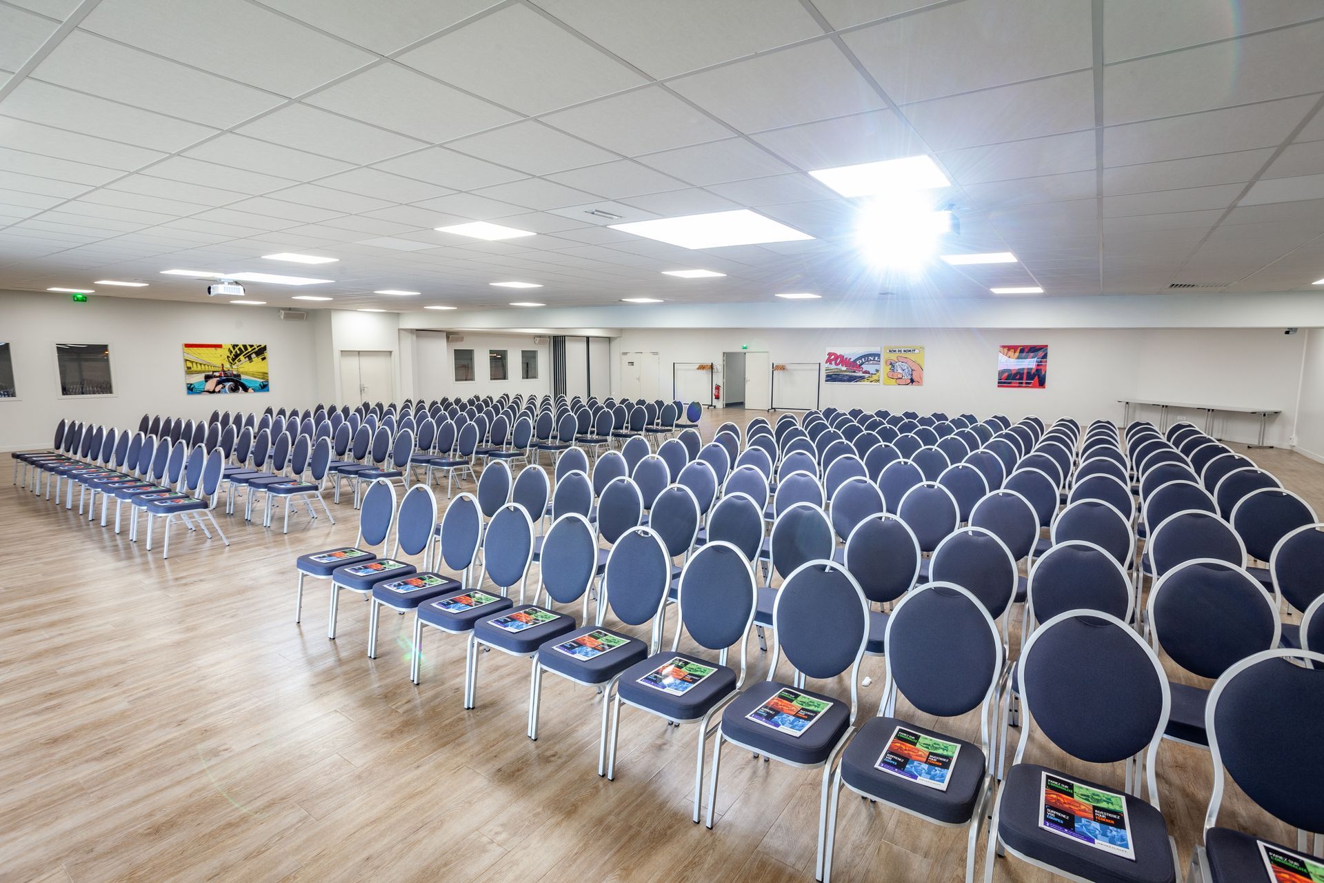 Une grande pièce avec des rangées de chaises bleues