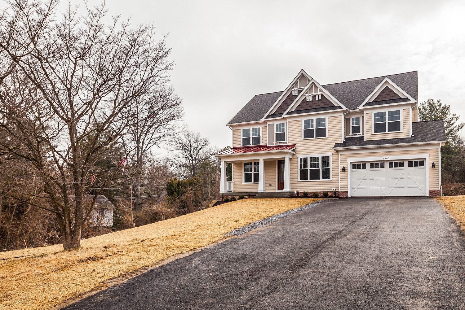 A large house with a driveway leading to it is sitting on top of a hill.