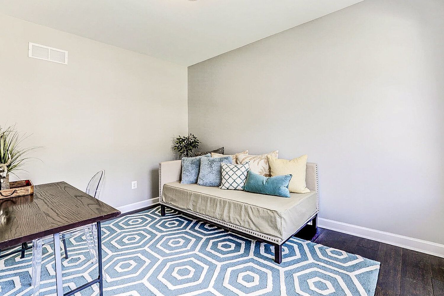 A living room with a couch , table and rug.