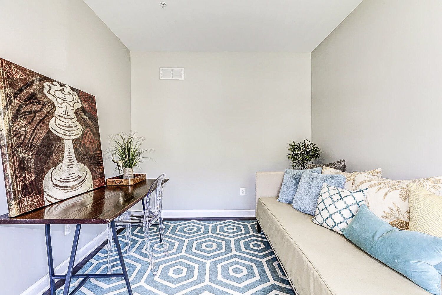 A living room with a couch , desk , and rug.