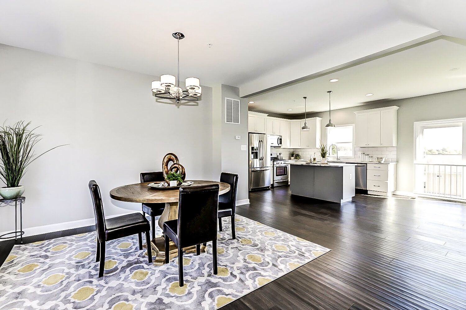 A dining room with a table and chairs and a rug.