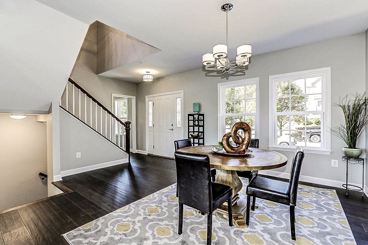 A dining room with a table and chairs and a chandelier.