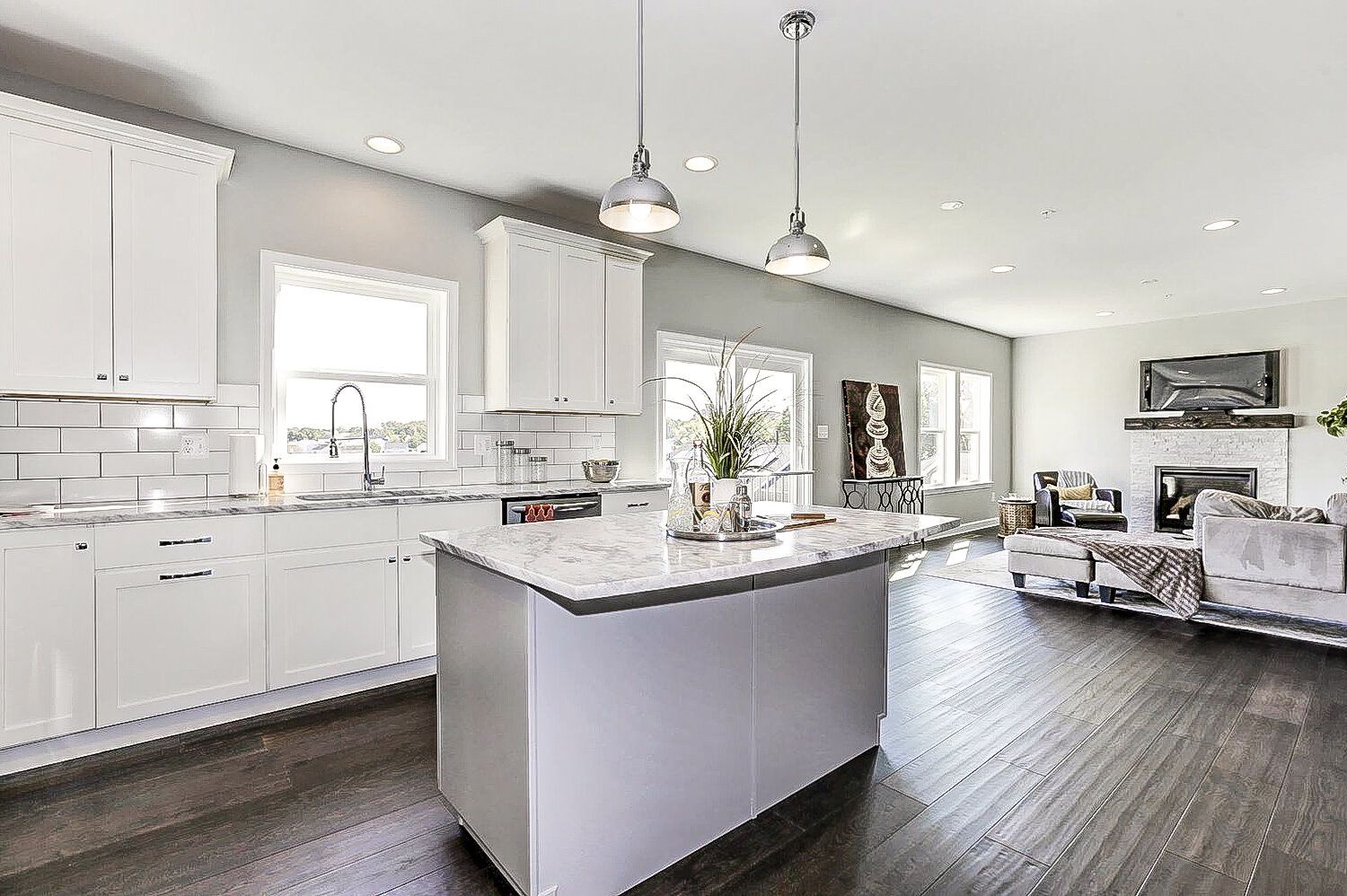 A kitchen with white cabinets and a large island in the middle of the room.