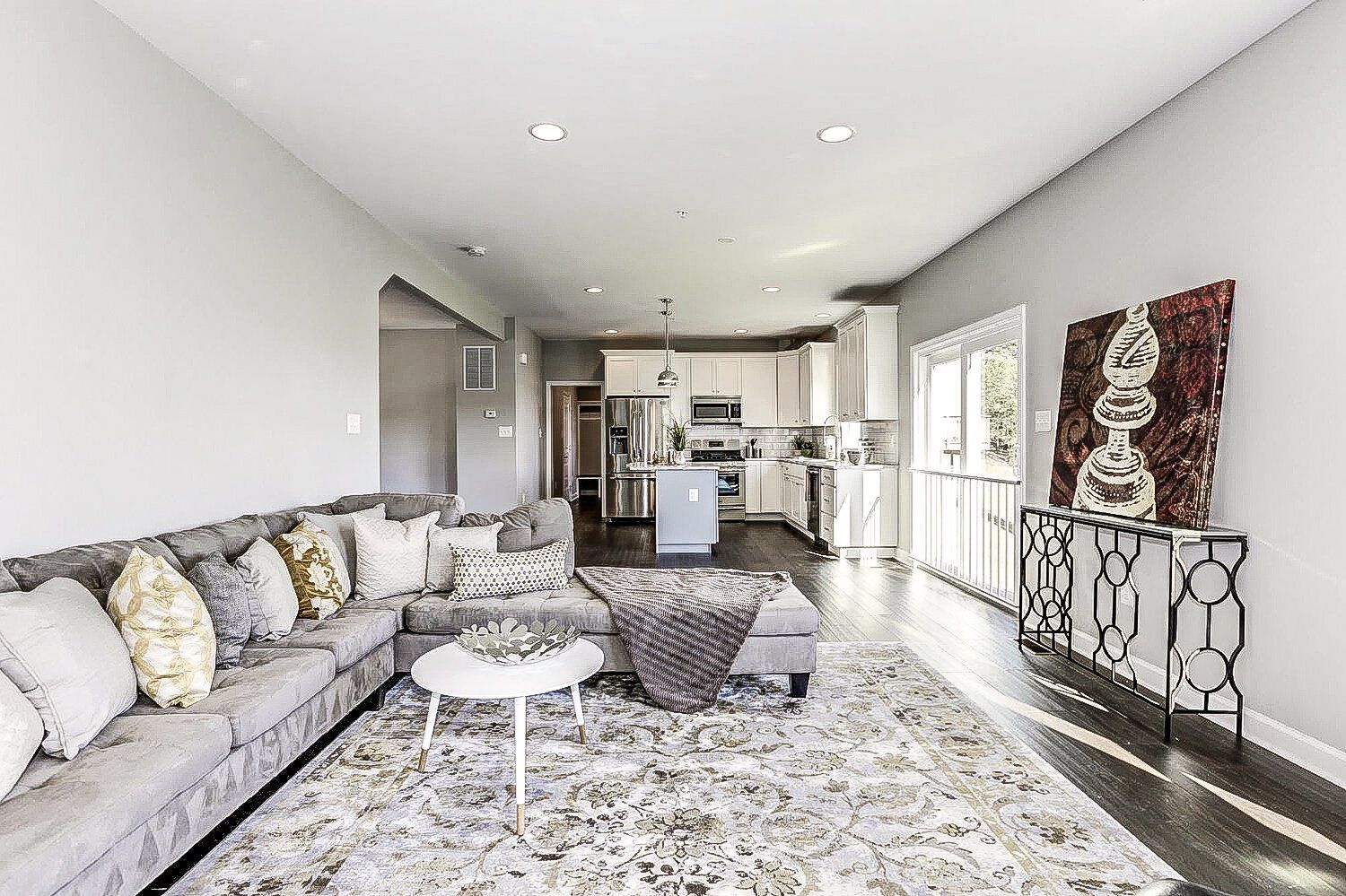 A living room with a large sectional couch and a rug.