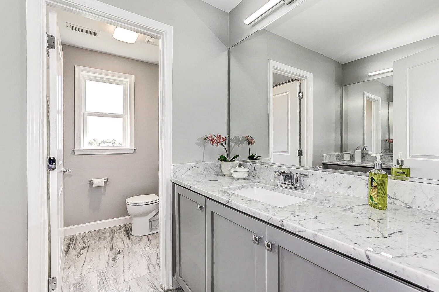 A bathroom with a sink , toilet and mirror.