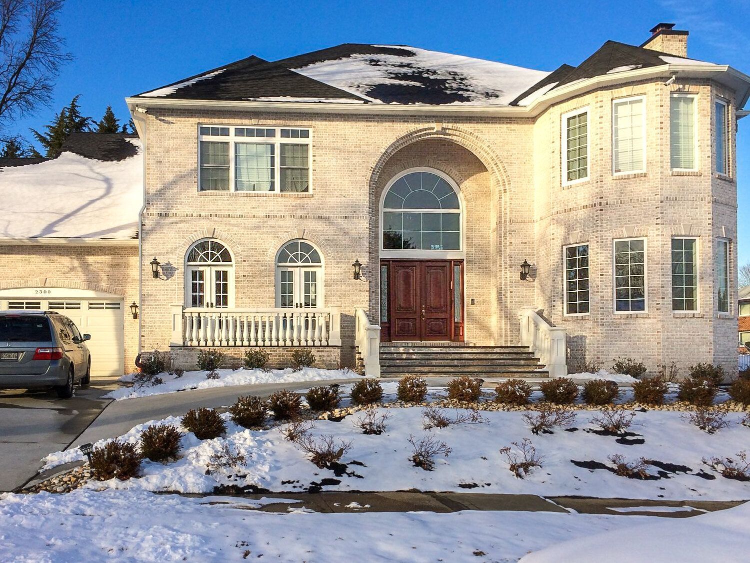 A large house with a car parked in front of it