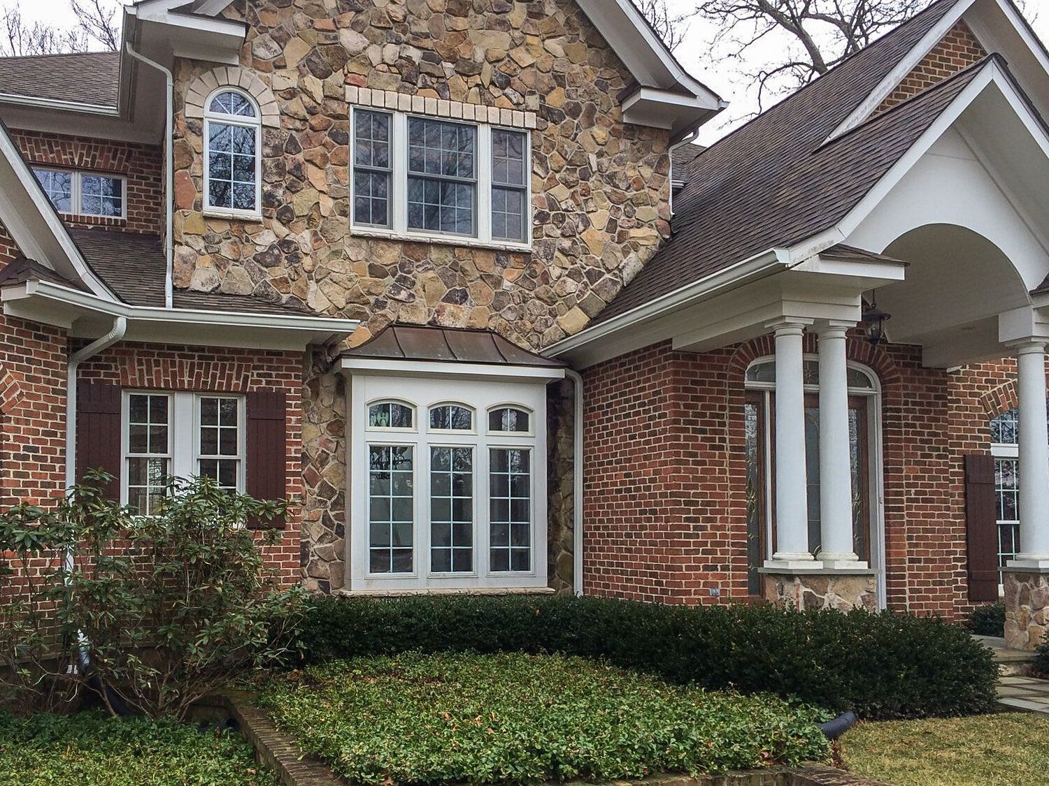 A large brick house with a stone facade and white windows