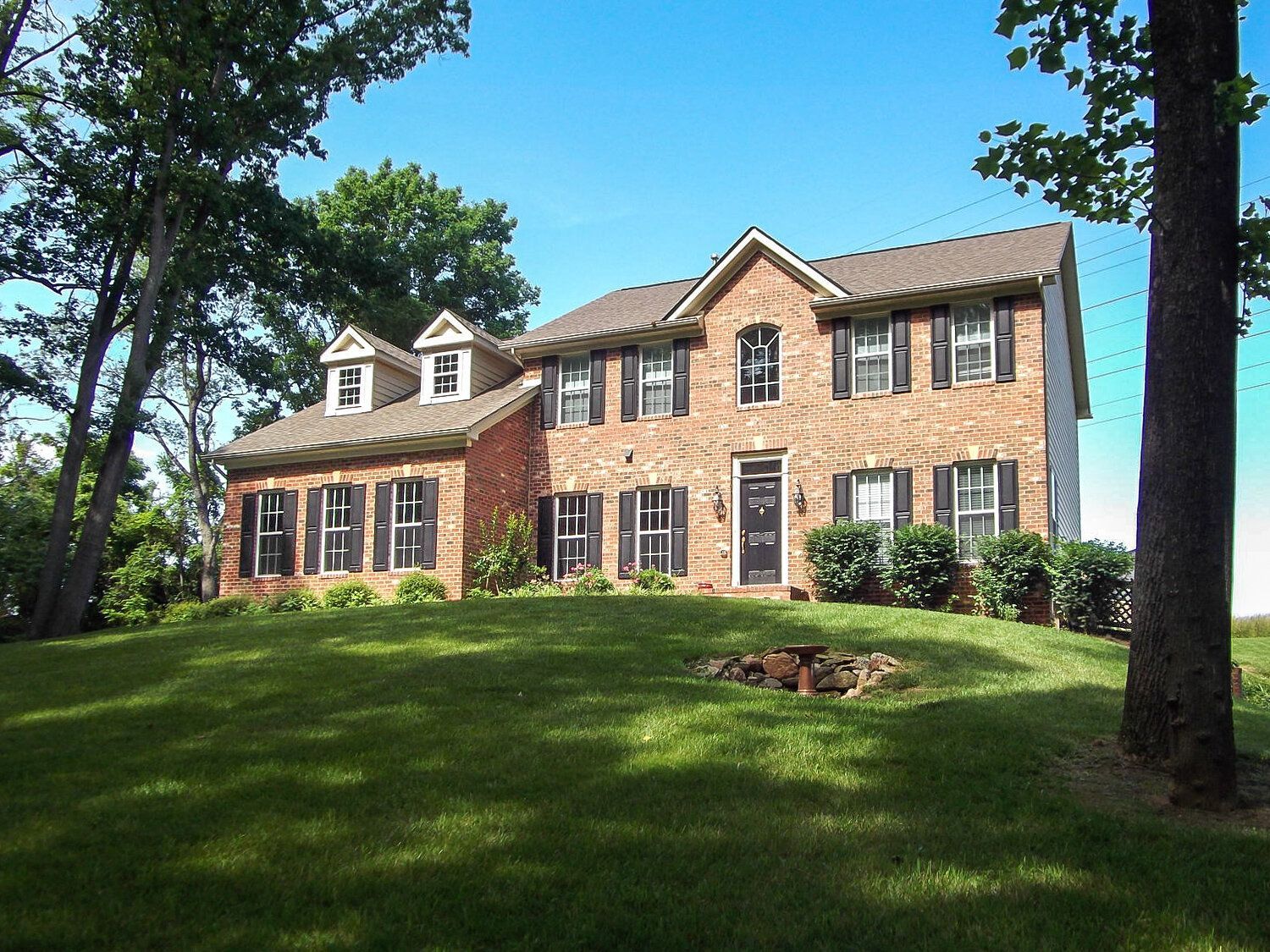 A large brick house with a tree in front of it