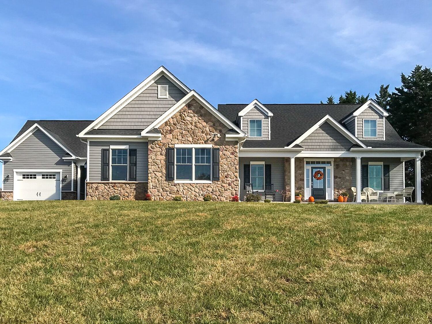 A large house is sitting on top of a grassy hill.