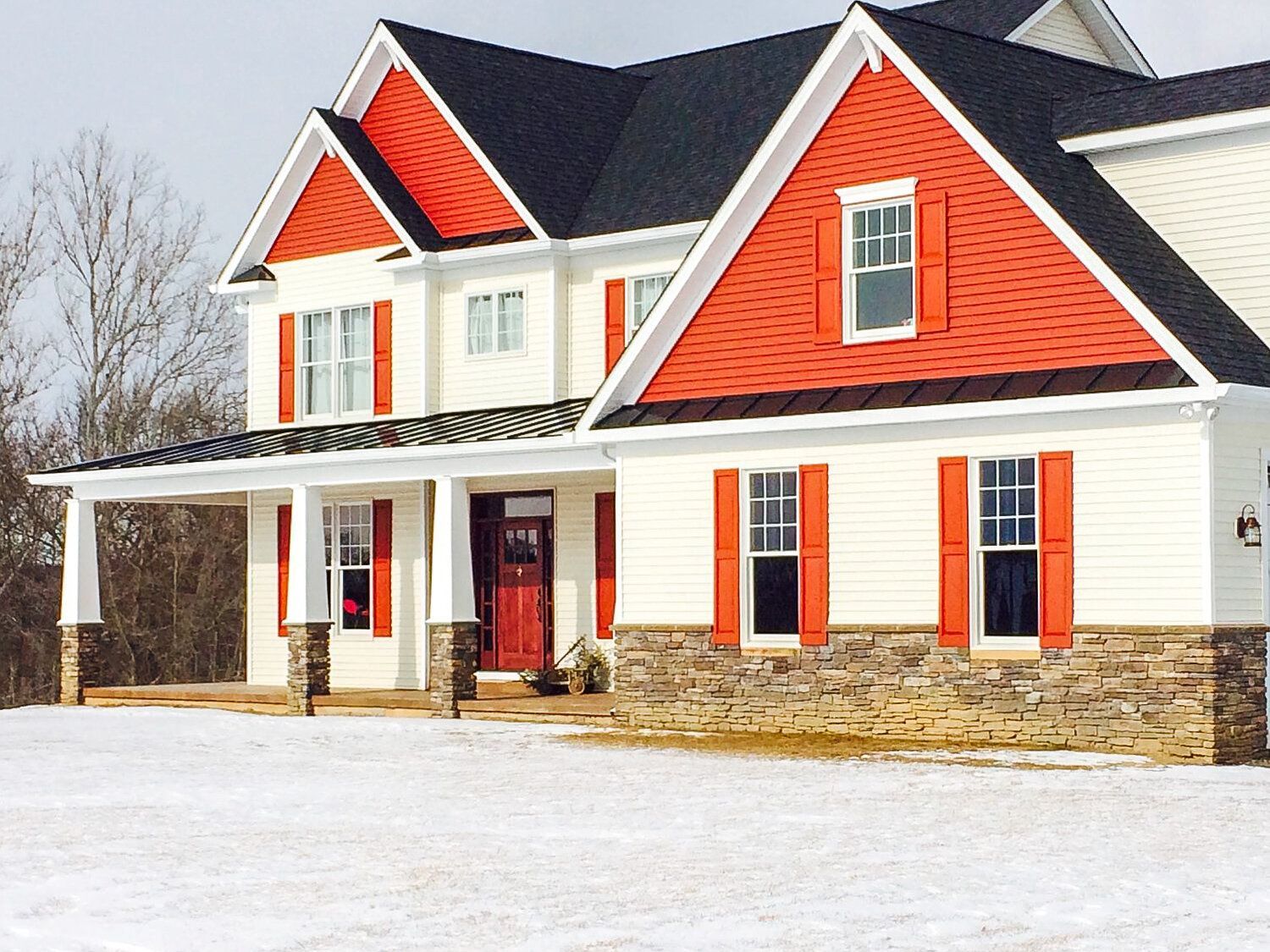 A white house with red shutters and a black roof