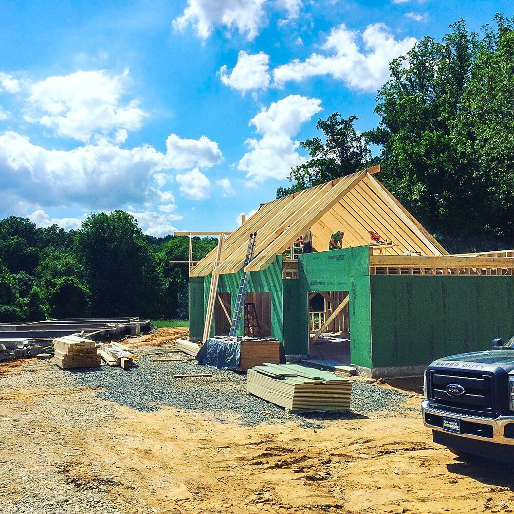 A truck is parked in front of a house under construction
