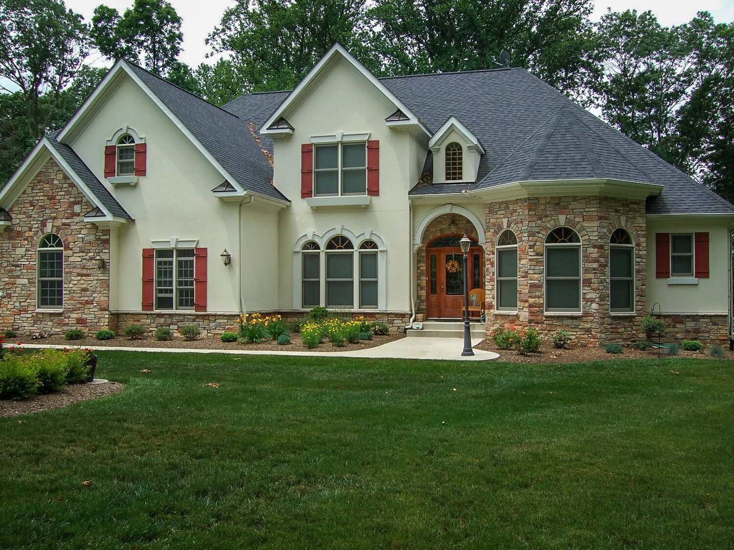 A large white house with red shutters on the windows