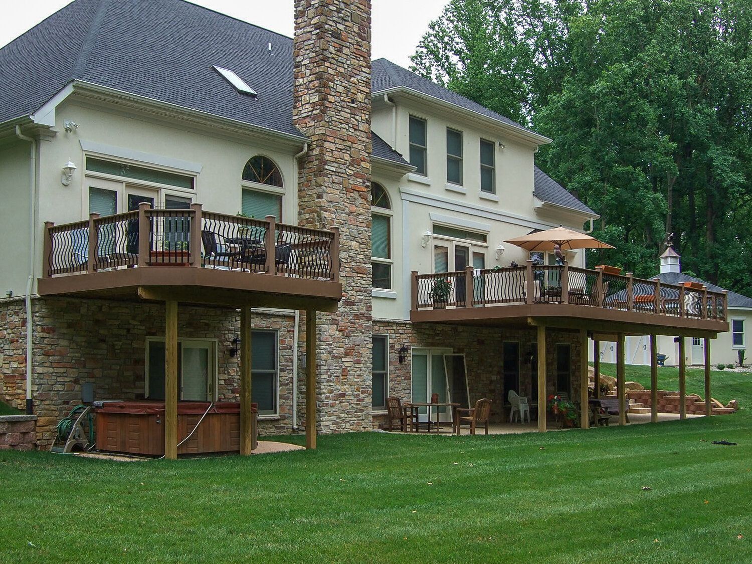 A large house with a large deck and a hot tub
