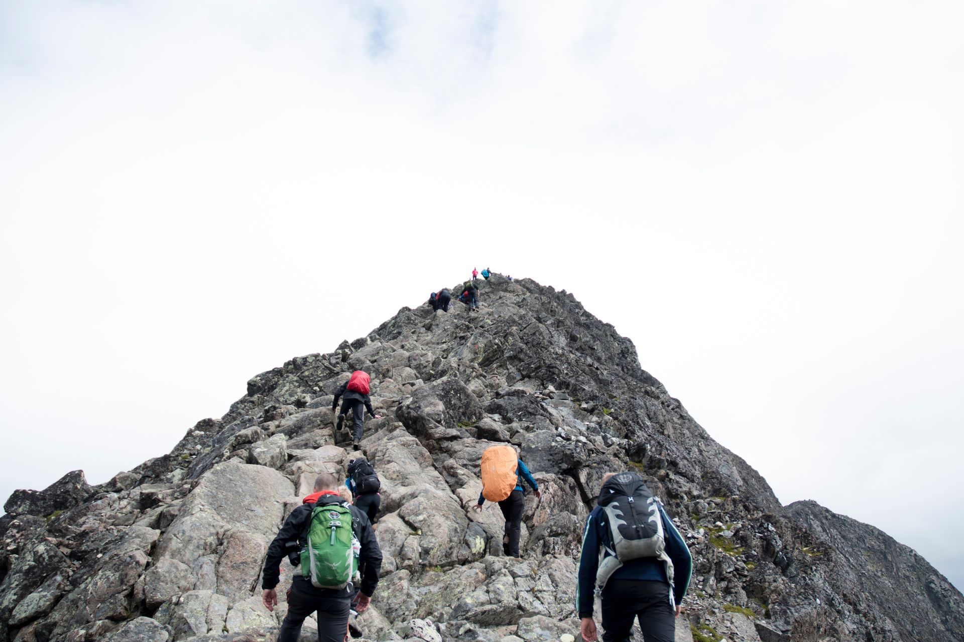 A group of people are hiking up a rocky mountain.
