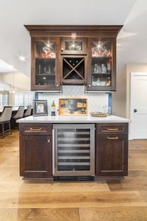 A kitchen with white cabinets and a stove top oven with red knobs.