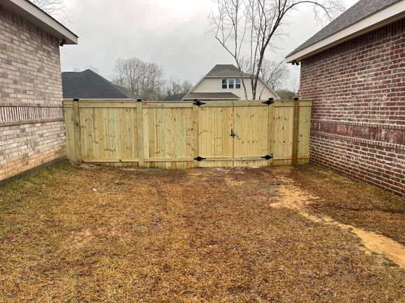 A Wooden Fence Is in The Backyard of A Brick House - Mississippi, United States - Magnolia Fencing, LLC