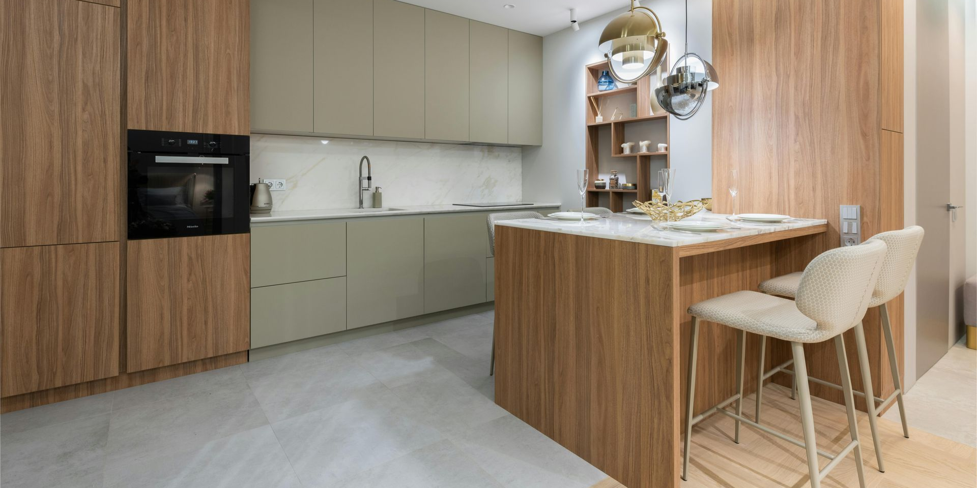 Modern kitchen with wood cabinets, light green countertops, and a breakfast bar with stools.