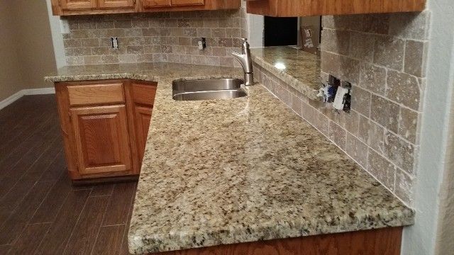 Kitchen with granite countertops, wood cabinets, and tile backsplash. Sink and faucet visible.