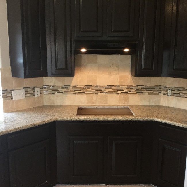 Dark brown kitchen cabinets, granite countertops, and tiled backsplash.
