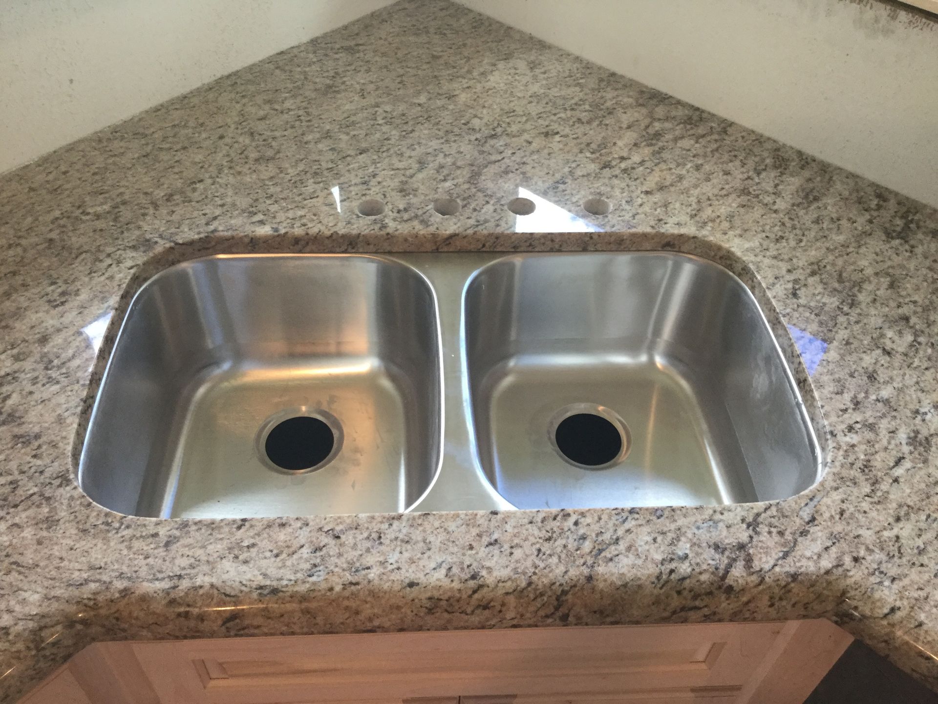Stainless steel double sink set into a granite countertop.